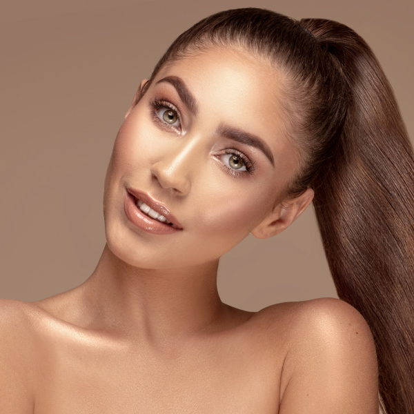 Beauty portrait of attractive brunette woman with healthy straight long hair and delicate makeup.