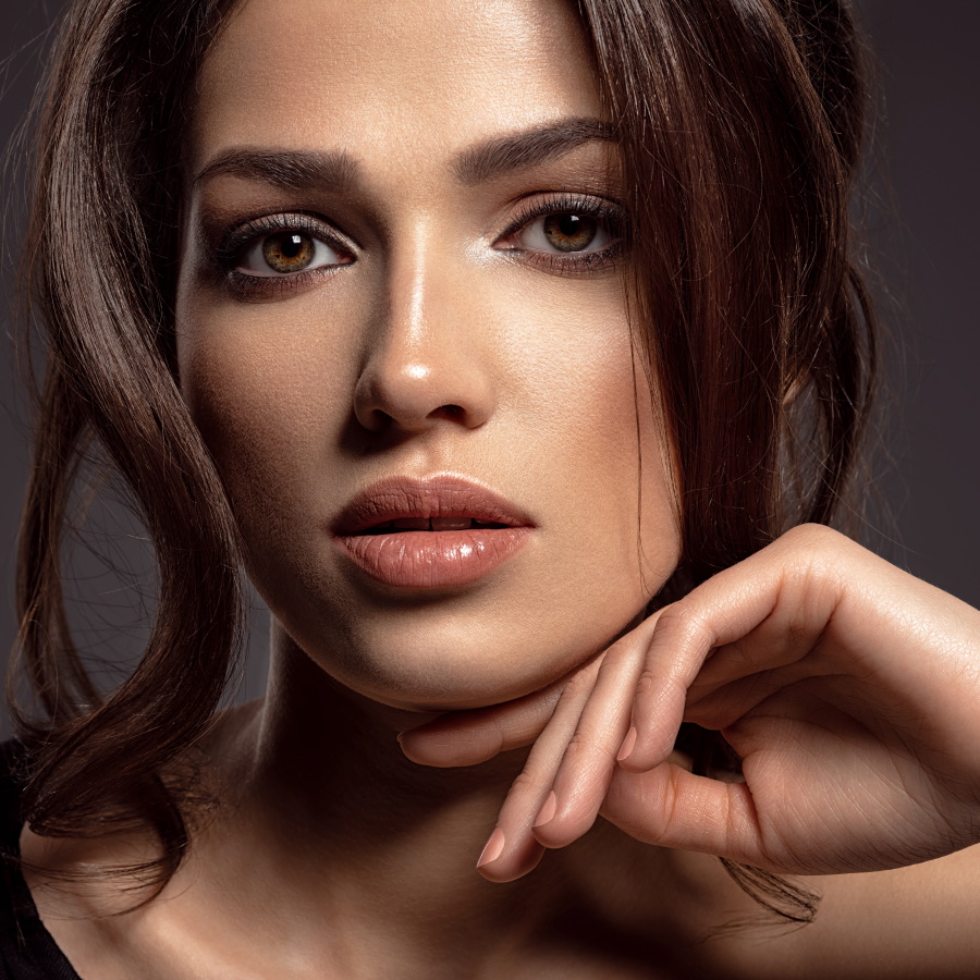 Beautiful woman with brown hair. Attractive model with brown eyes. Fashion model with a smokey makeup. Closeup portrait of a pretty woman looks at camera. Sexy woman.