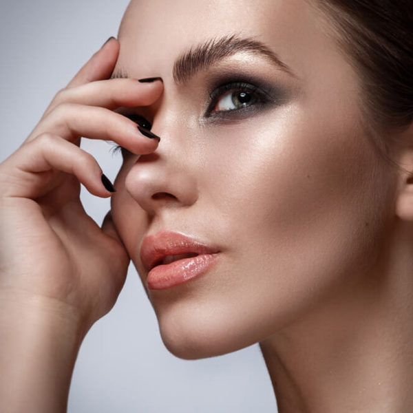 woman touching eyebrow